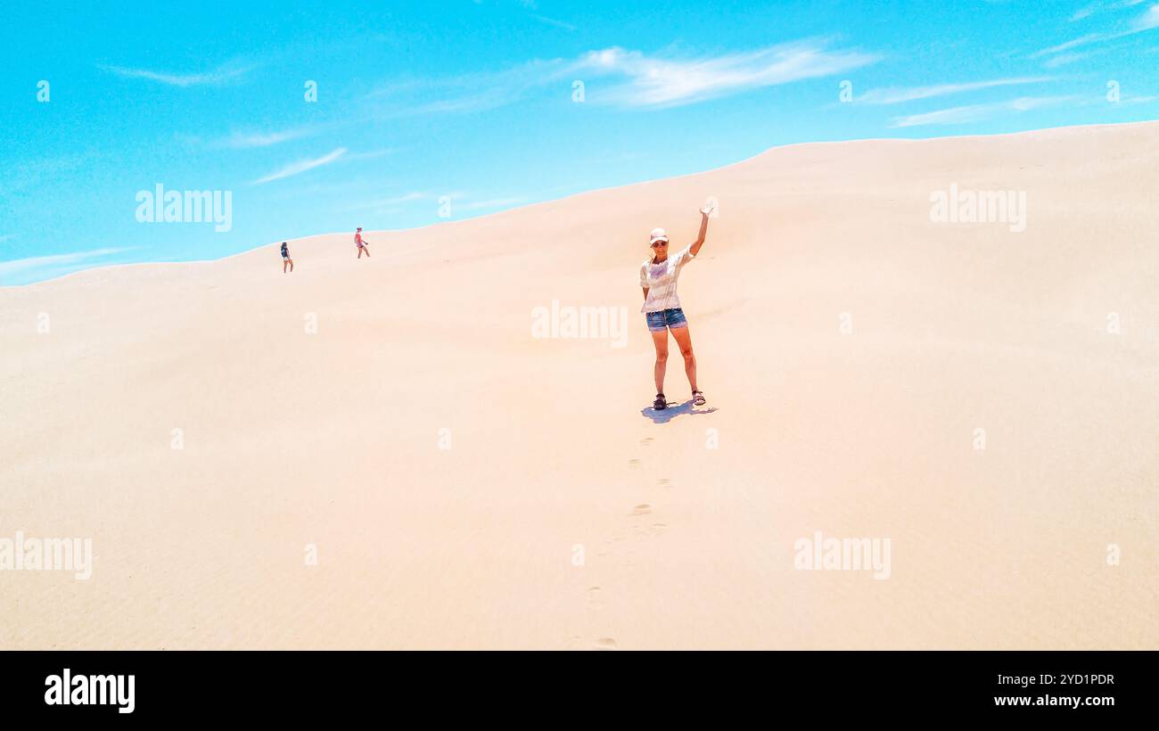 Australische Frau, die im Sommer die riesigen Sanddünen genießt Stockfoto