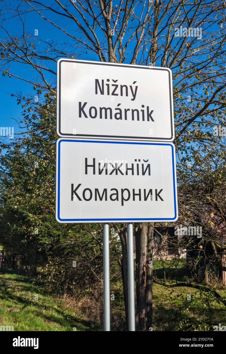 Verkehrsschild des Dorfes in lateinischer und kyrillischer Schrift, im Dorf Nižný Komárnik, in der Nähe von Svidnik, Region Prešov, Slowakei Stockfoto