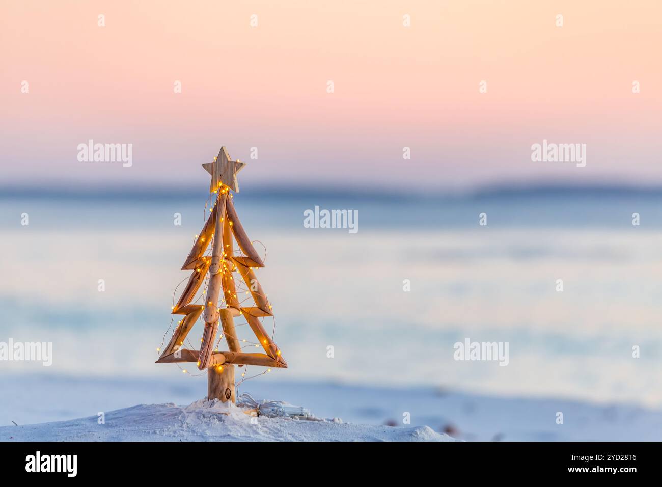 Weihnachtsbaum mit Feenlichtern am Strand im Sommer Stockfoto