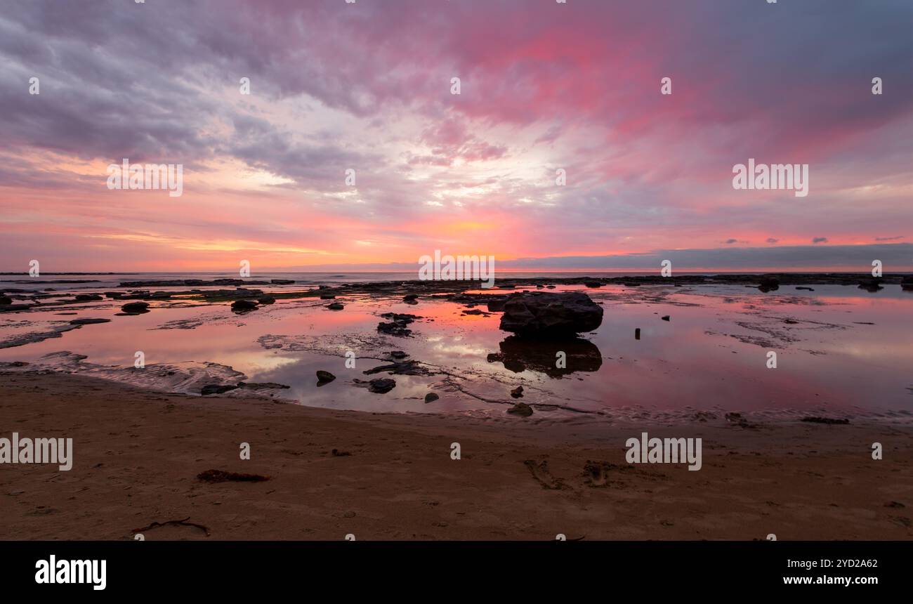 Morgenfarben des Sonnenaufgangs bemalen den Himmel und spiegeln sich im Gezeitenwasser. Platz zum Kopieren. Lage: Bateau Bay Australien Stockfoto