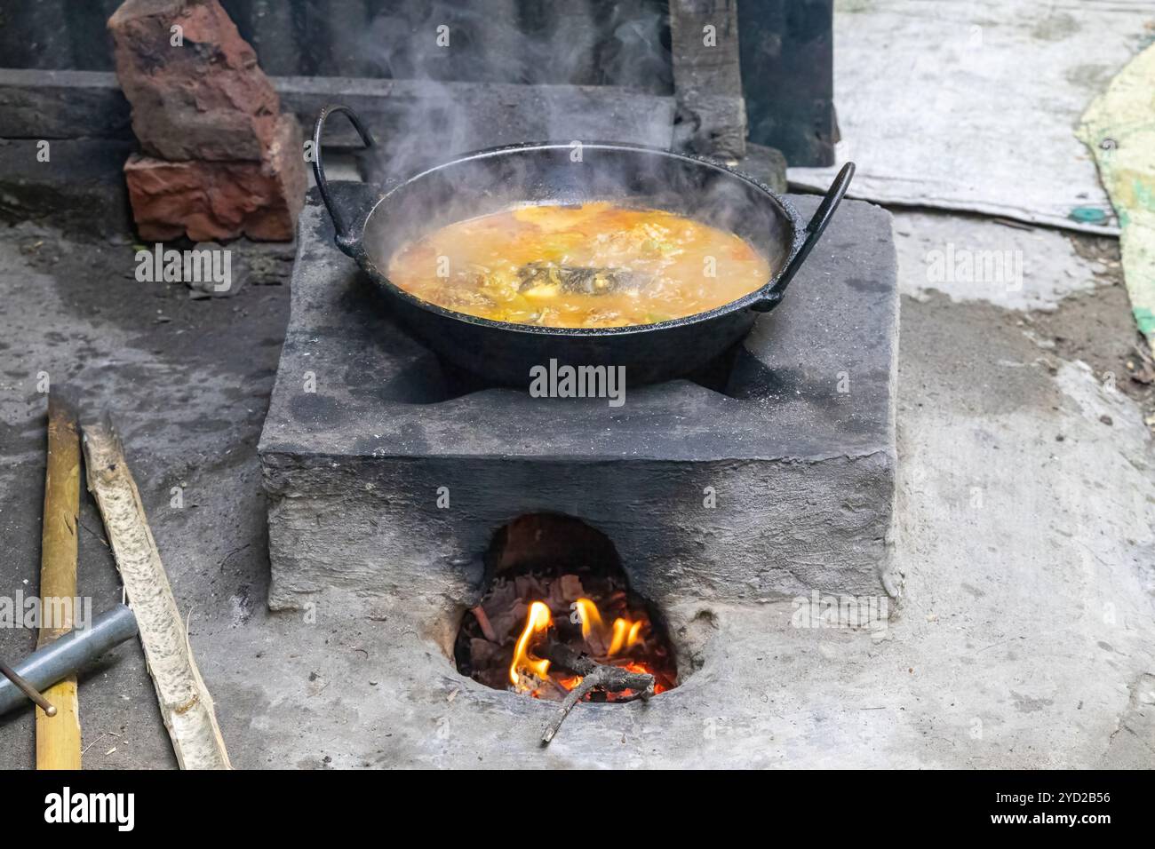 Fisch-Curry-Kochen auf einem traditionellen Schlammofen. Dorfküche in Bangladesch. Diese Öfen aus Lehm und mit Holz befeuert, werden häufig von den Bewohnern verwendet Stockfoto