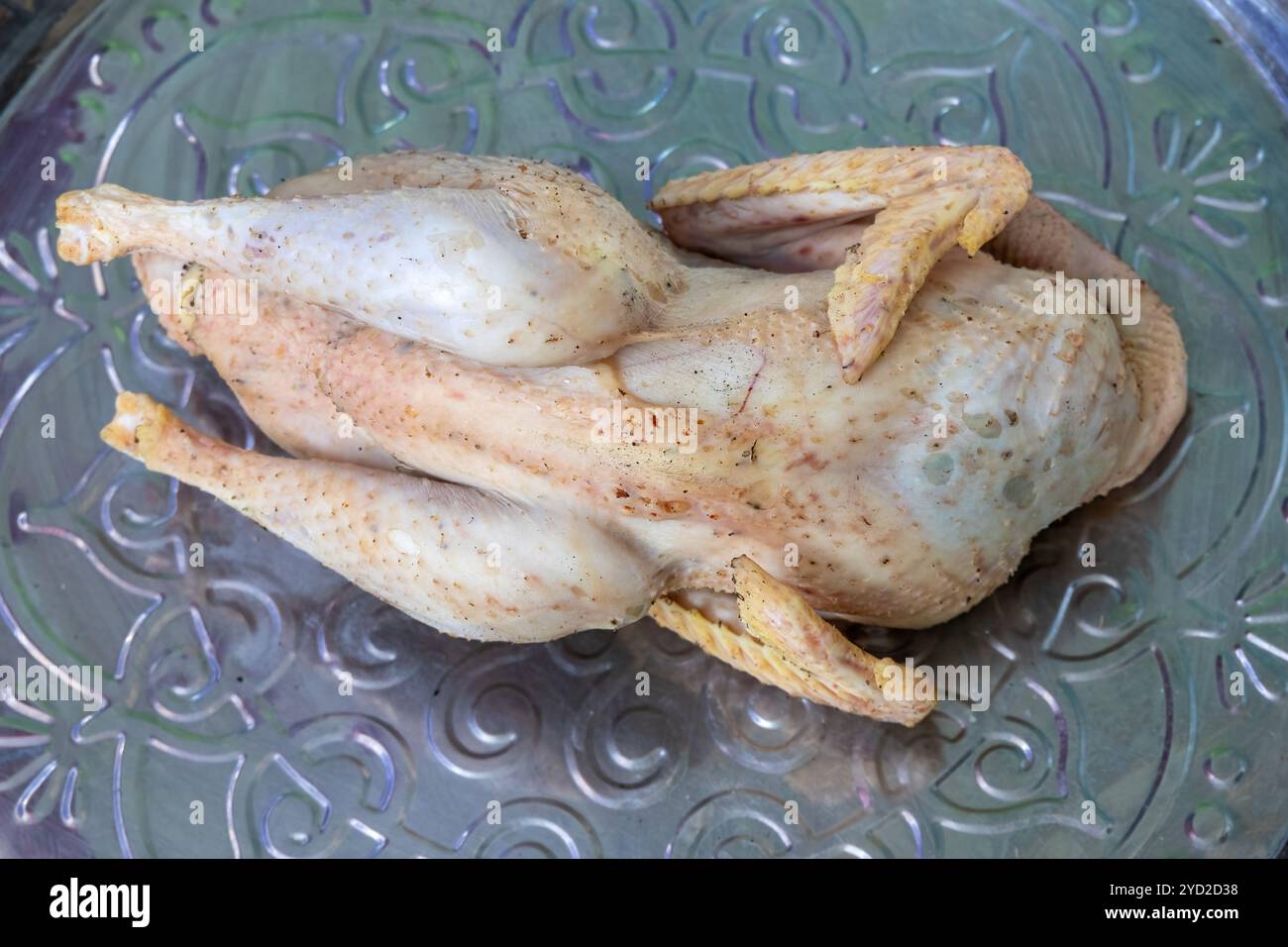 Ein rohes, biologisches Hühnchen ist bereit zum Kochen. Nahaufnahme eines Desi-Hühnerschlachtkörpers ist in einem Gericht zum Kochen. Sie wuchs auf einem Dorfhaus in Bangladesch auf. Stockfoto