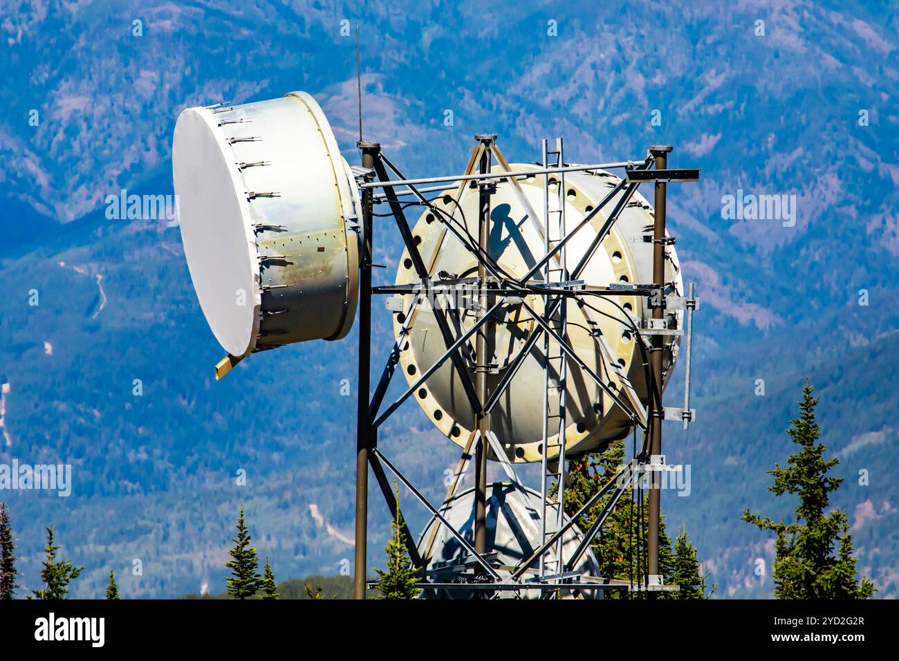 Eine Nahaufnahme und detaillierte Schuß auf der Oberseite einer Mobilfunk Basisstation, zwei kreisförmige Mikrowelle Antennen zu einem stahlgitter Turm untergebracht sind. Stockfoto