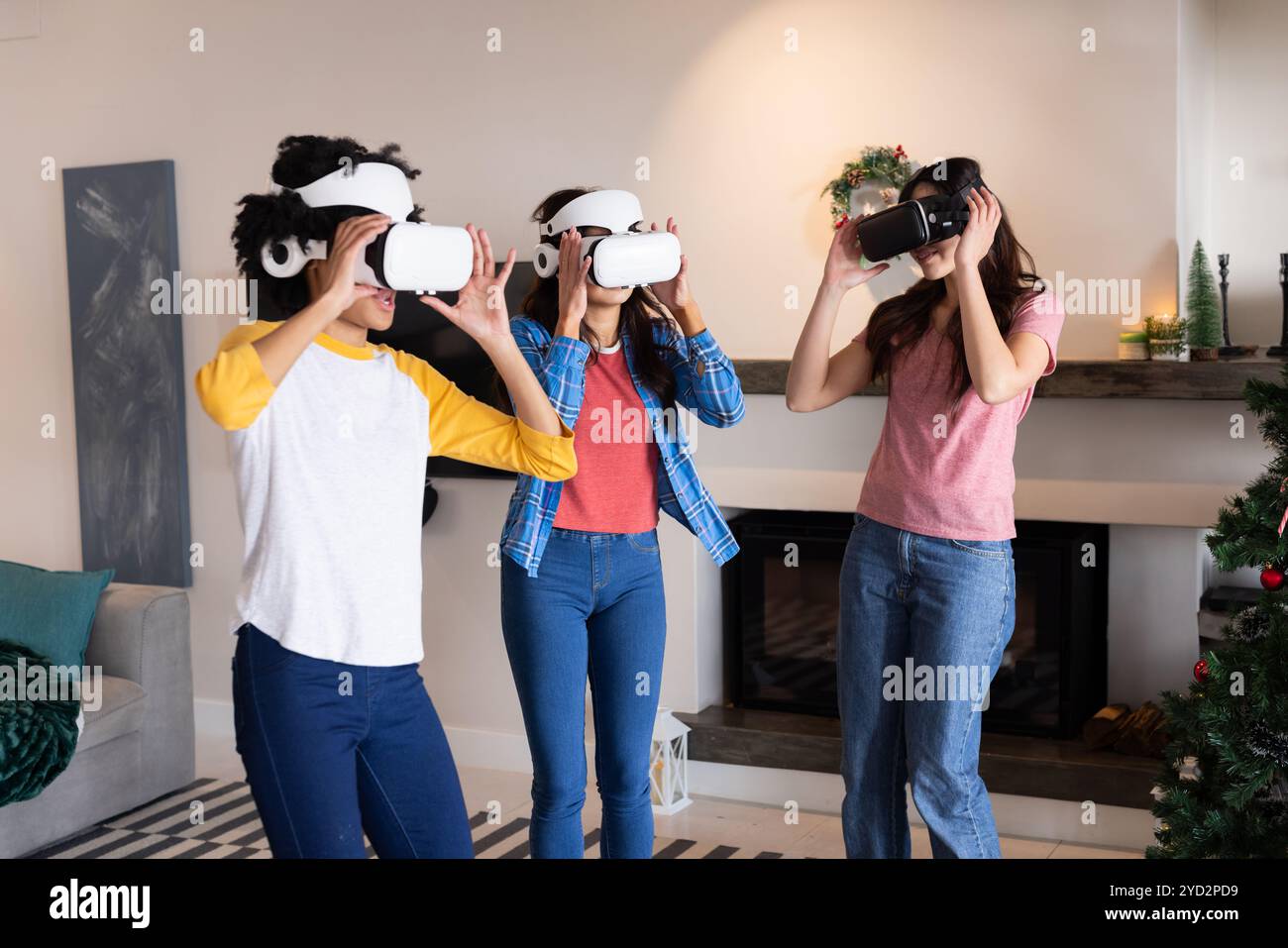 Gemeinsame Freundinnen genießen während der Weihnachtsfeier ein Virtual-Reality-Erlebnis zu Hause Stockfoto