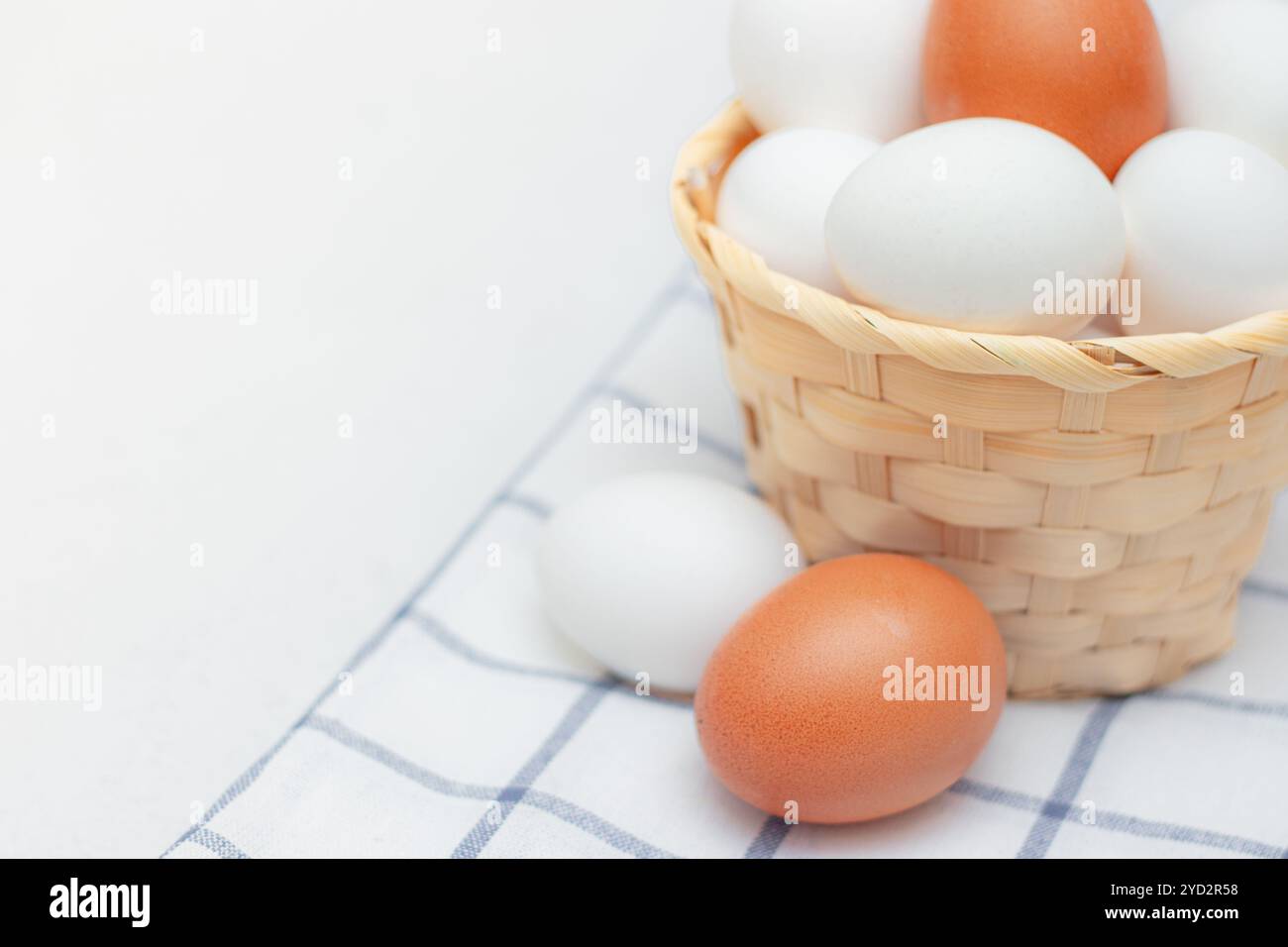 Hühnereier auf einem karierten Küchentuch auf einem Lichttisch. Das Konzept der landwirtschaftlichen Erzeugnisse und der natürlichen Ernährung. Artikel über Haushaltsprodukte Stockfoto