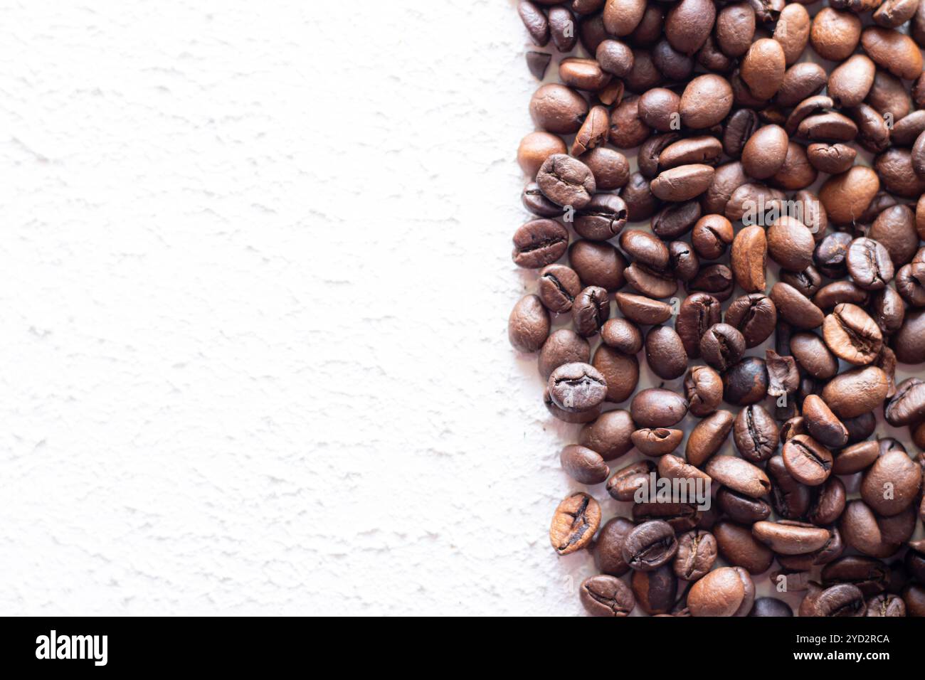 Kaffeebohnen sind auf einem hellen Hintergrund verstreut. Frische Kaffeebohnen. Konzept der Werbung für Kaffee, Kaffeebohnen, Cafés. Stockfoto