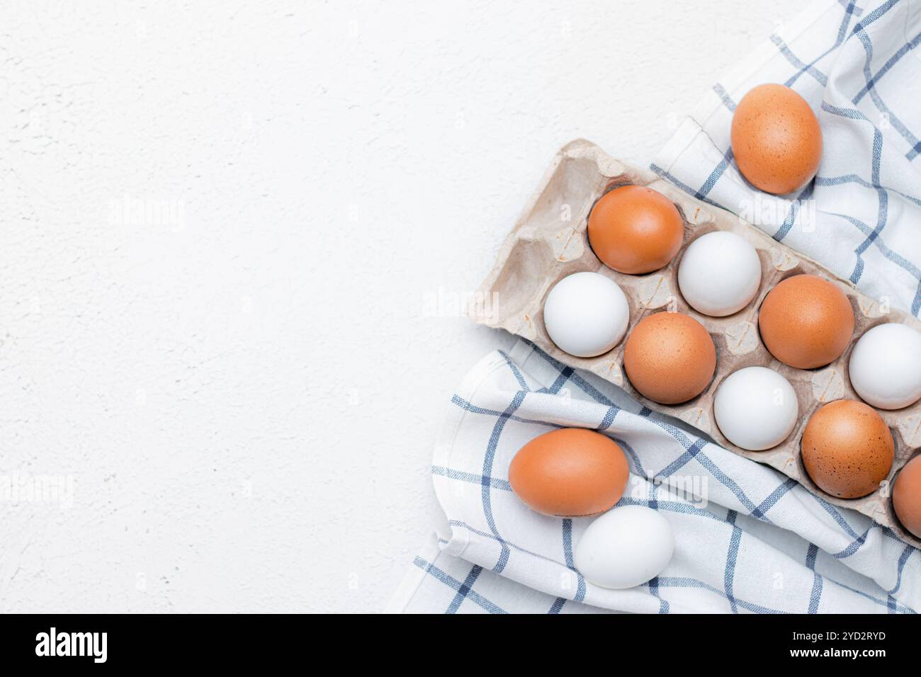 Hühnereier auf einem karierten Küchentuch auf einem Lichttisch. Das Konzept der landwirtschaftlichen Erzeugnisse und der natürlichen Ernährung. Artikel über Haushaltsprodukte Stockfoto