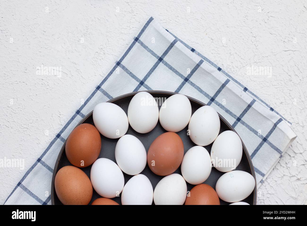 Hühnereier auf einem karierten Küchentuch auf einem Lichttisch. Das Konzept der landwirtschaftlichen Erzeugnisse und der natürlichen Ernährung. Artikel über Haushaltsprodukte Stockfoto