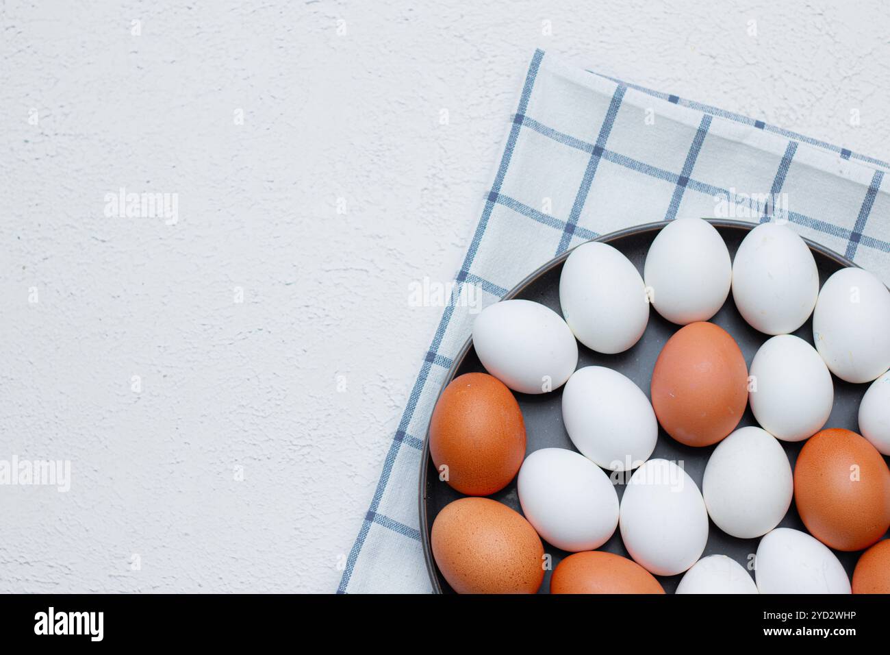 Hühnereier auf einem karierten Küchentuch auf einem Lichttisch. Das Konzept der landwirtschaftlichen Erzeugnisse und der natürlichen Ernährung. Artikel über Haushaltsprodukte Stockfoto