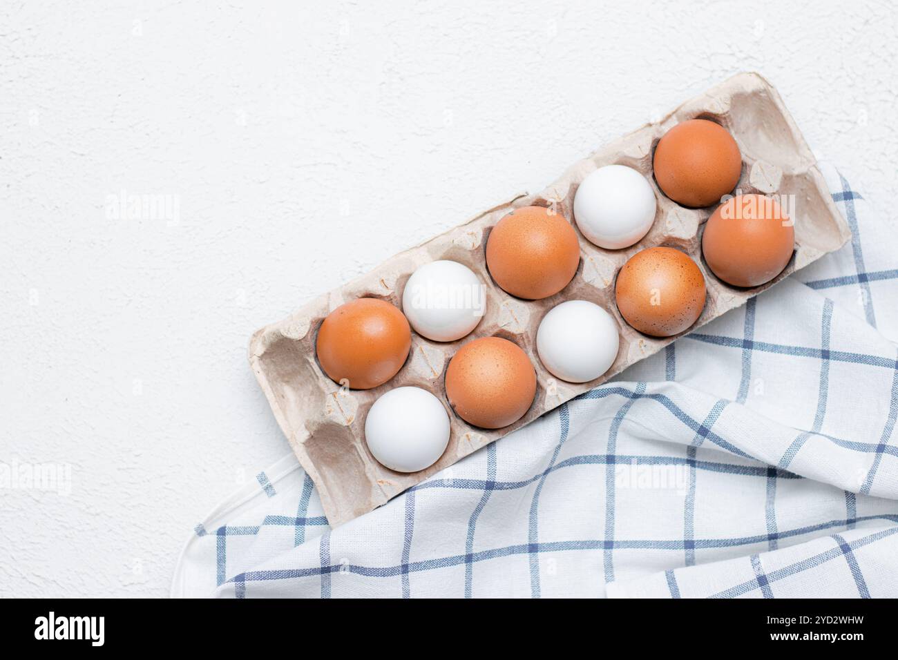 Hühnereier auf einem karierten Küchentuch auf einem Lichttisch. Das Konzept der landwirtschaftlichen Erzeugnisse und der natürlichen Ernährung. Artikel über Haushaltsprodukte Stockfoto