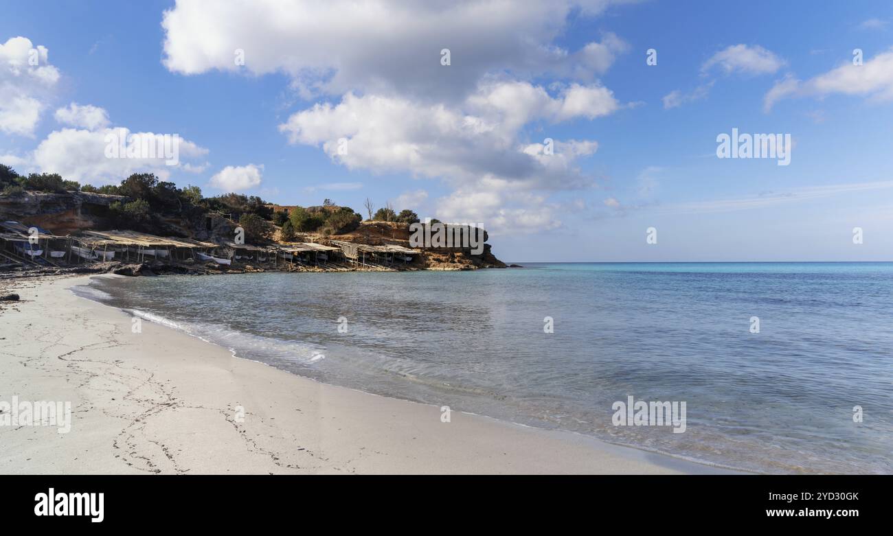 Viele alte Fischerhütten und Bootsgaragen am Strand und der Bucht von Cala Saona auf der Insel Formentera Stockfoto