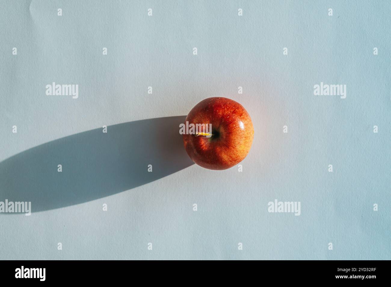Roter Apfel, der einen Schatten vor weißem Hintergrund bildet Stockfoto