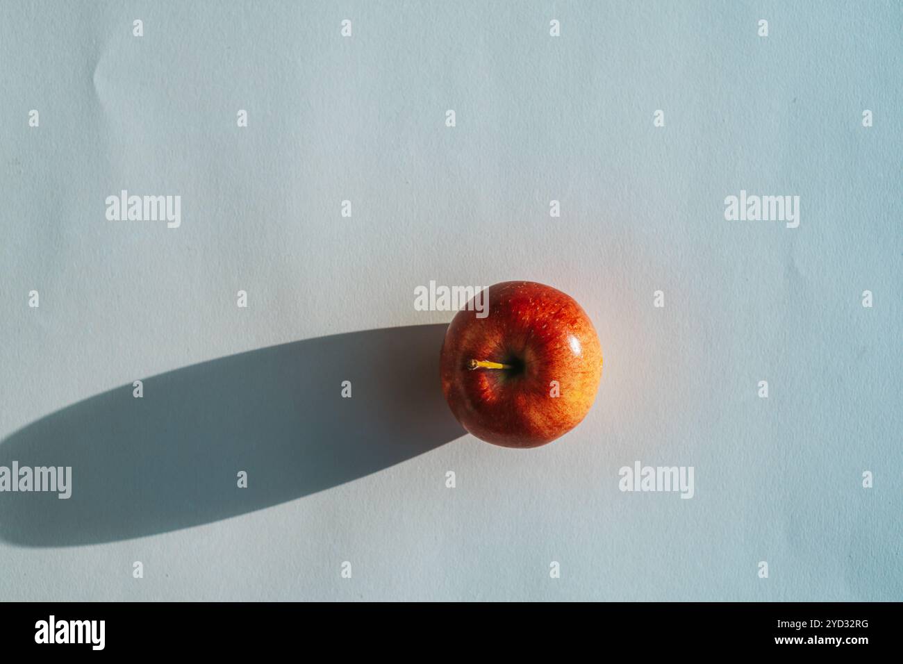 Roter Apfel, der einen Schatten vor weißem Hintergrund bildet Stockfoto