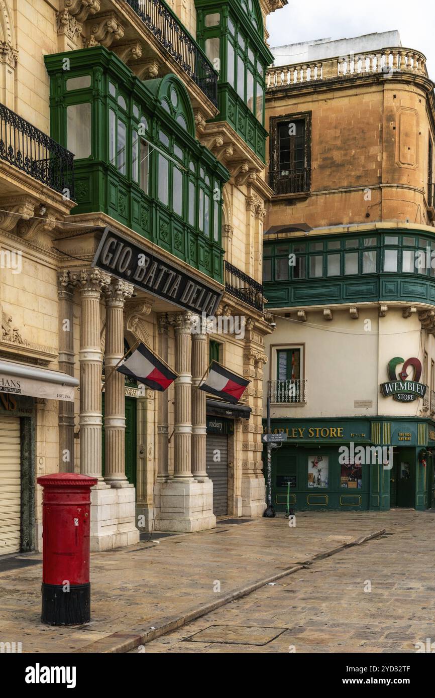 Valletta, Malta, 23. Dezember 2023: Typische Straße in der Innenstadt von Valletta mit grünen Gallarija-Balkonen und britischem Einfluss, Europa Stockfoto