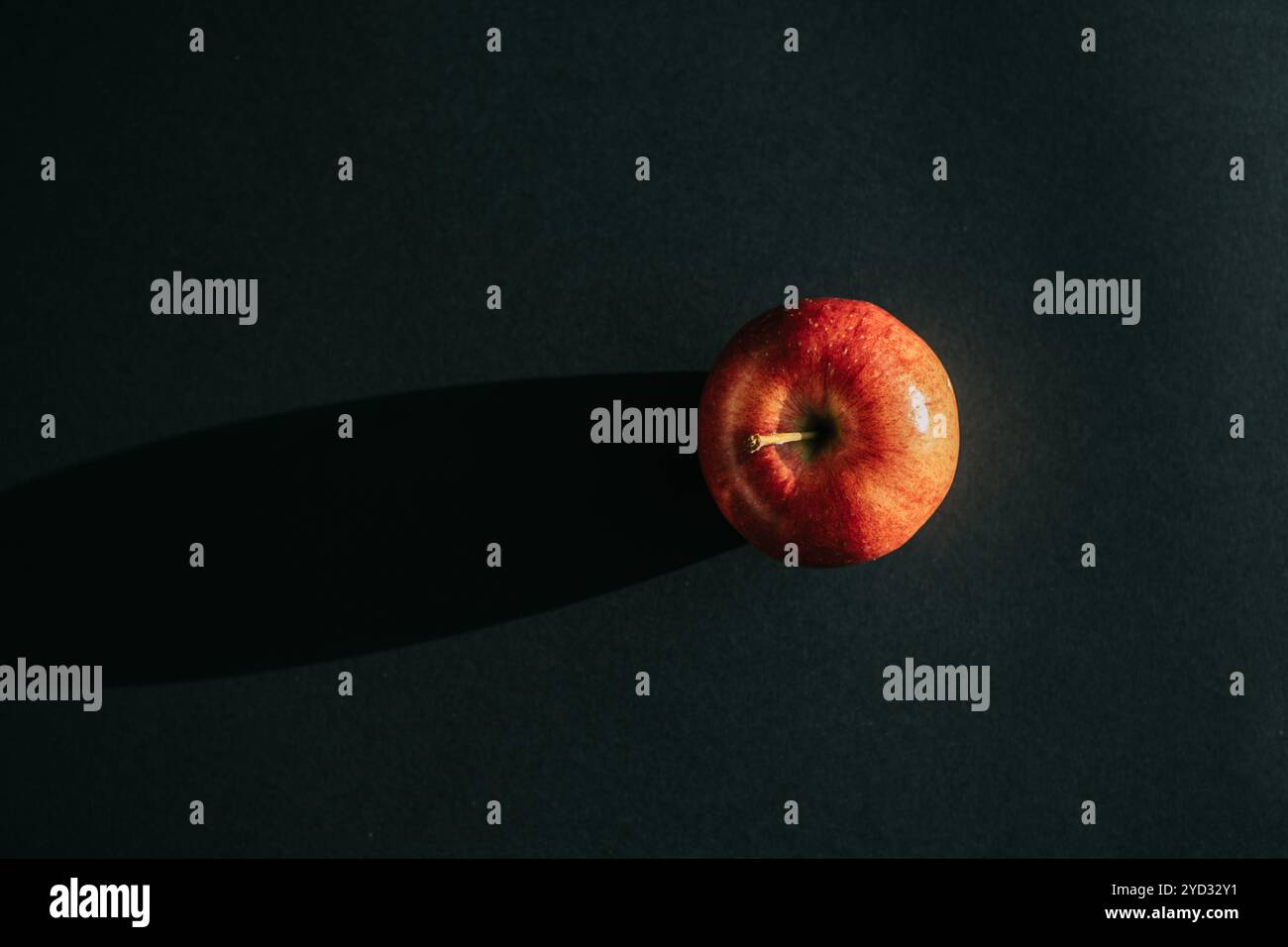 Roter Apfel, der einen Schatten vor schwarzer Umrandung bildet Stockfoto
