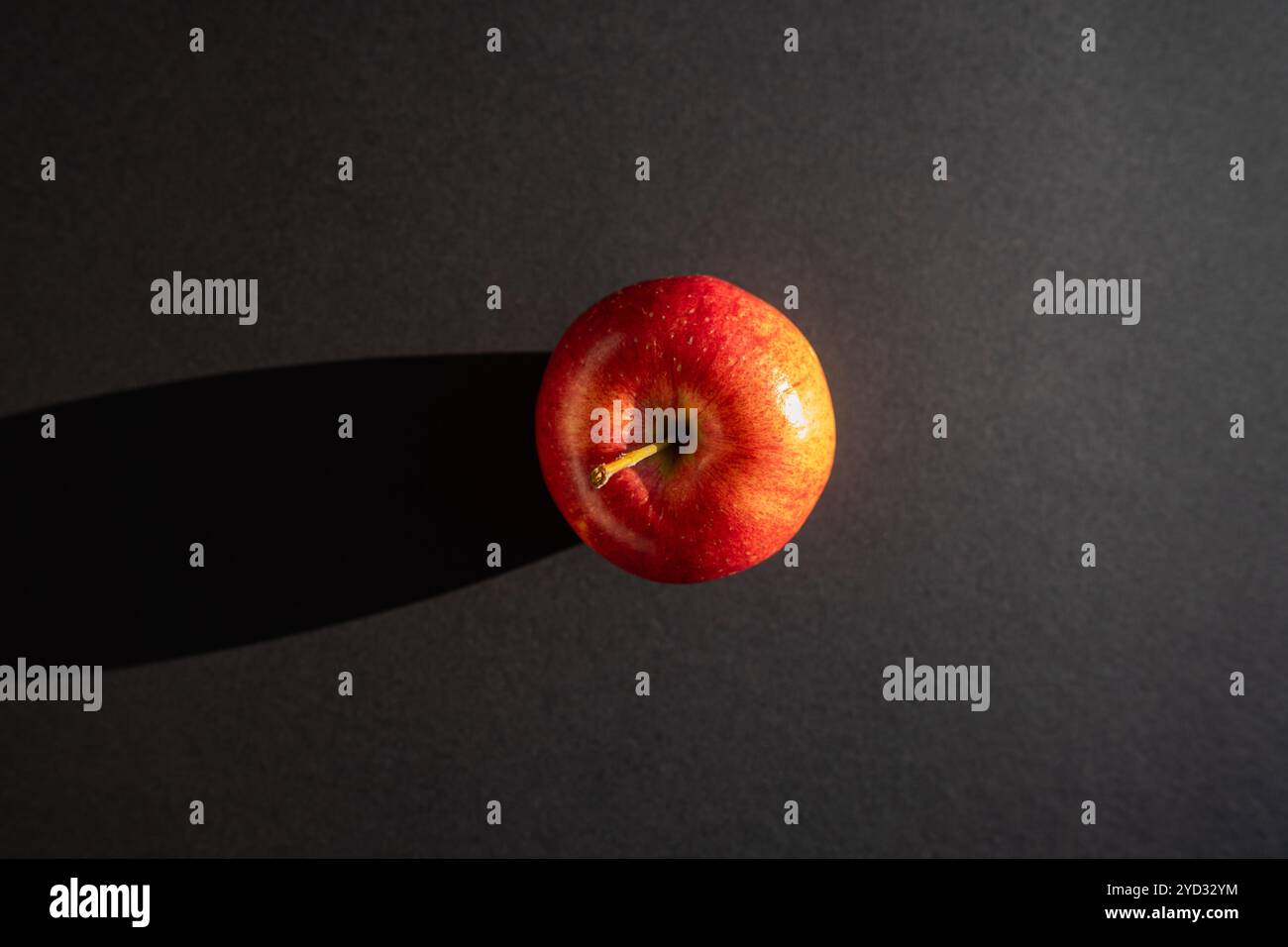 Roter Apfel, der einen Schatten vor schwarzer Umrandung bildet Stockfoto