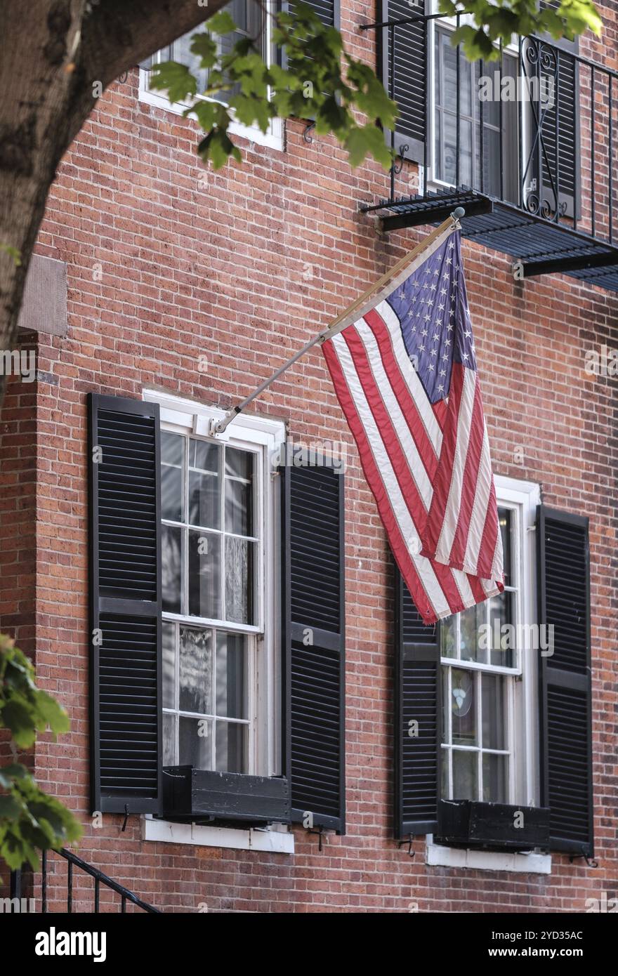 Eine US-Flagge, die vor Einem traditionellen Brownstone Townhouse in der Gegend von Beacon Hill in Boston hängt Stockfoto