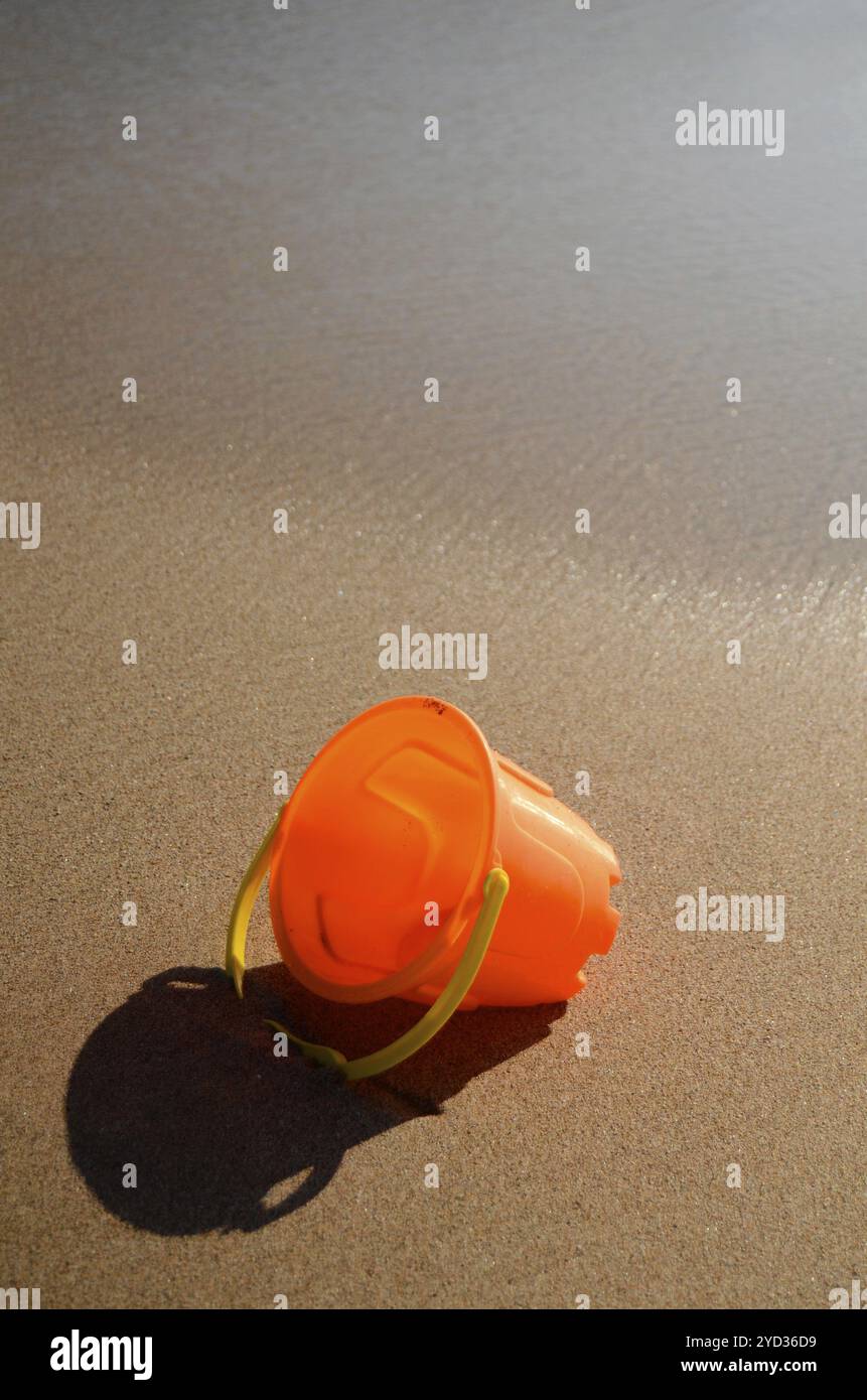 Urlaub-Bild von einem Kinderspielzeug im nassen Sand von einem tropischen Strand mit Textfreiraum Stockfoto