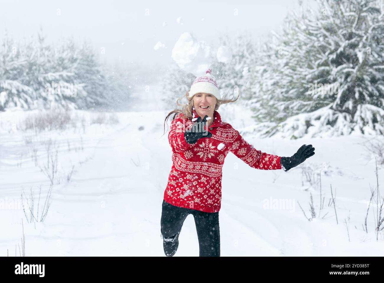 Schneebälle fliegen durch die Luft, während sie Frauen die Hände hinterlassen Stockfoto