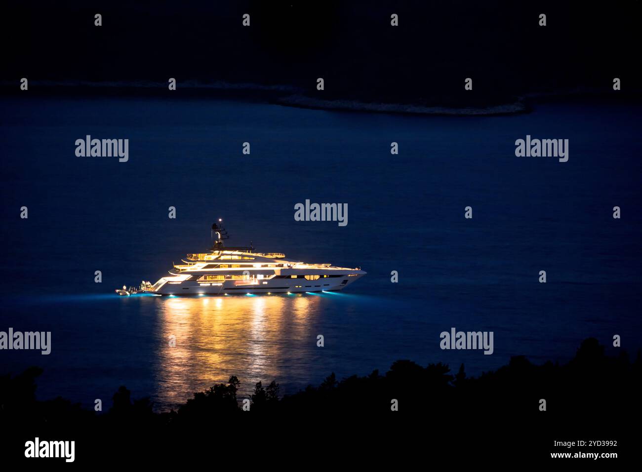 Beleuchtete Superyacht auf dem Meer bei Nacht, Sommerurlaub Stockfoto