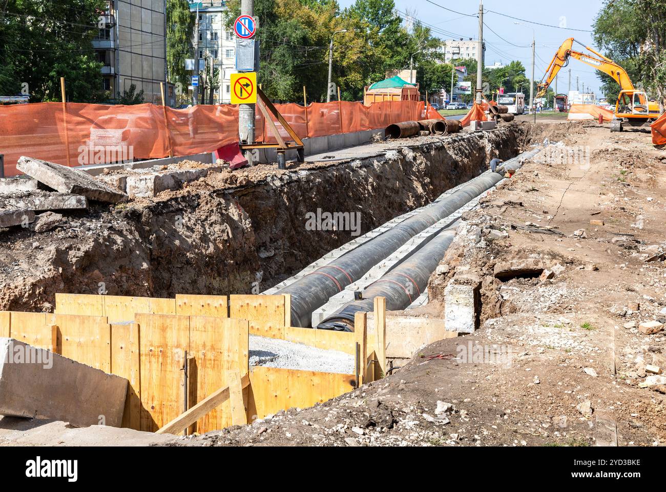 Die Bauarbeiten auf großen Eisen Rohre in einer Tiefe von ausgehobenen Grabens Stockfoto