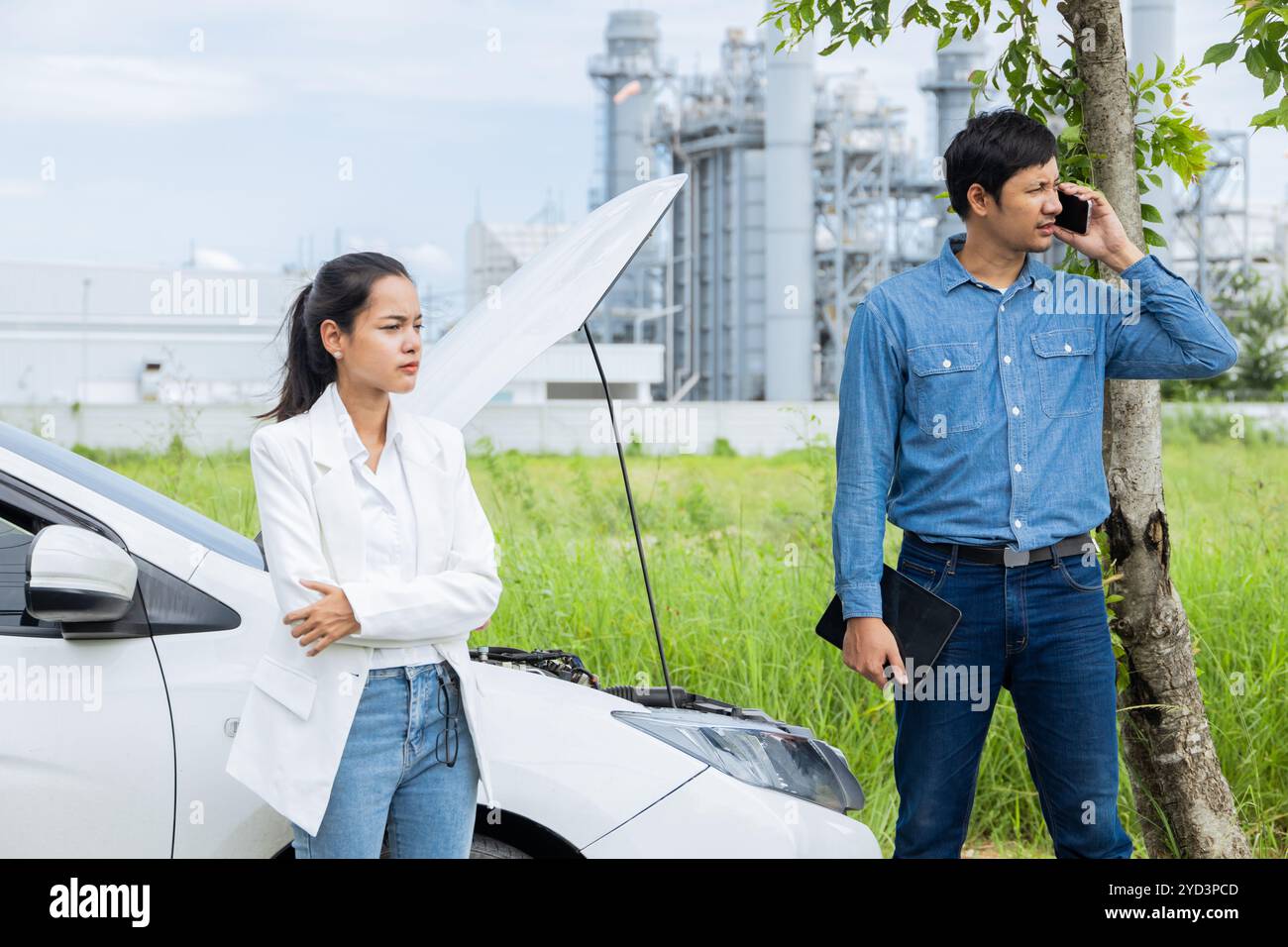 Frauenwagen auf der Straße kaputt. Ein junges Paar, das den Motor auf einer malerischen Straße überprüft Stockfoto