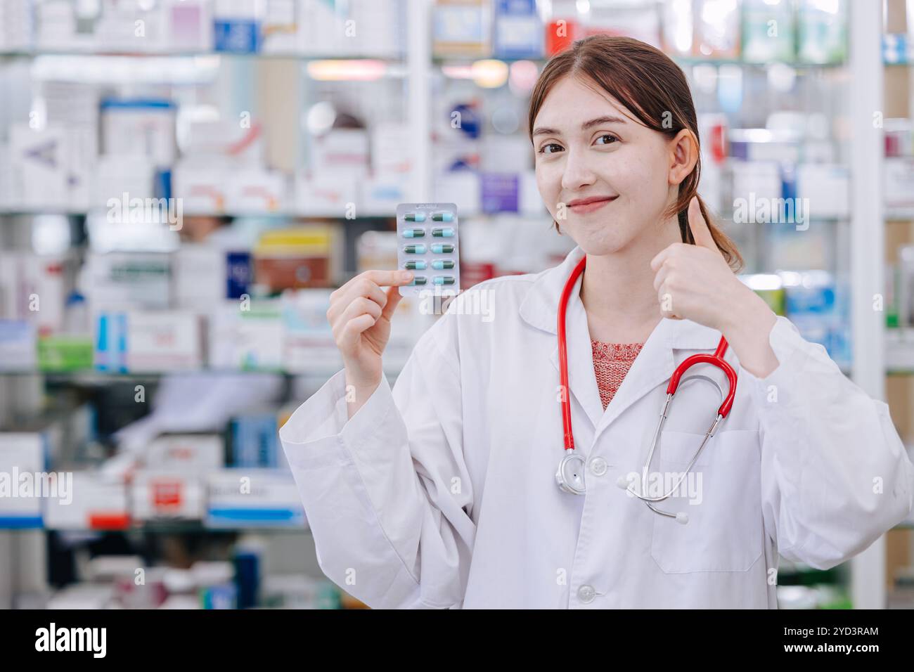 Glücklicher Apotheker glücklich lächelnd Daumen hoch in Drogeriemarkt genehmigen Verkauf guter Medizin für die Gesundheit, Medikamente Gesundheitsproblem für ein gutes Leben. Stockfoto