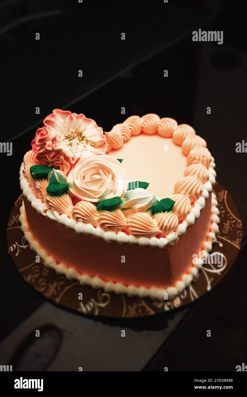 Eleganter Kuchen in Herzform mit Blumenmuster – perfekt für Jahrestage, Hochzeiten, Geburtstage und besondere Anlässe | cremige Layers & atemberaubendes Peach to Stockfoto