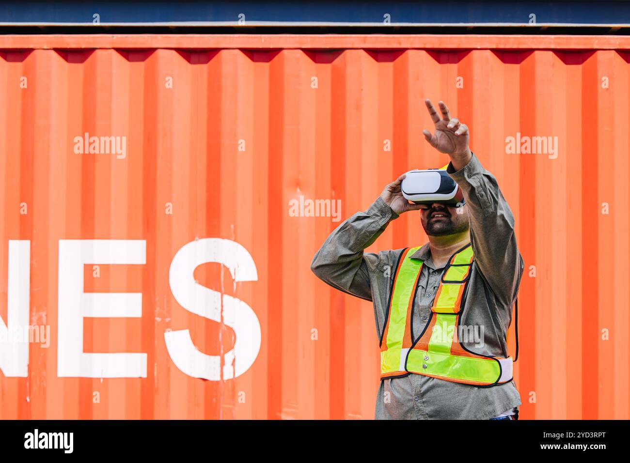 Mitarbeiter mit VR Vision Pro Technologie Headset-Gerät arbeiten auf der Baustelle Container Yard Innovation in der Logistikbranche Stockfoto