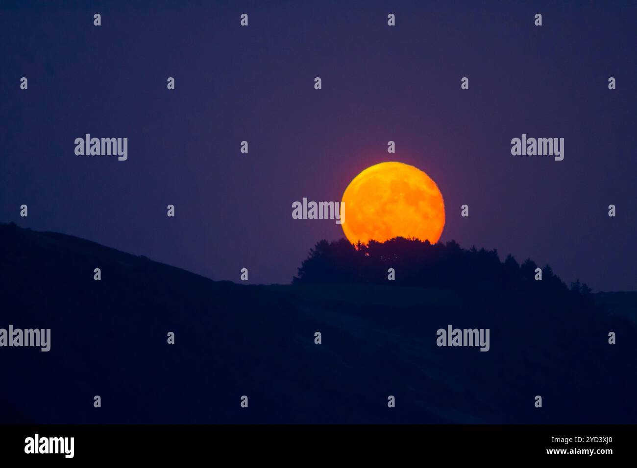 Teleobjektiv großer Sonnenaufgang über Seaton vom Plaidy Beach in der Nähe von Looe, Cornwall, Großbritannien, September. Stockfoto