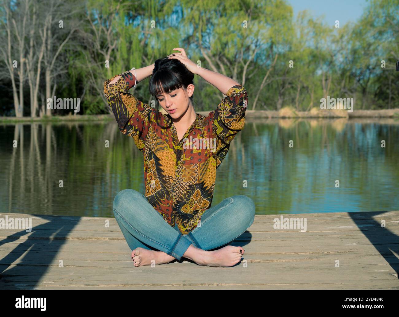 Frau, die neben einer künstlichen Lagune sitzt Stockfoto