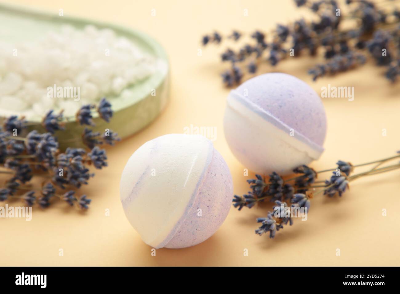 Naturkosmetik. Handgemachte Lavendelbadebomben und Lavendelblüten auf beigem Hintergrund. Draufsicht Stockfoto