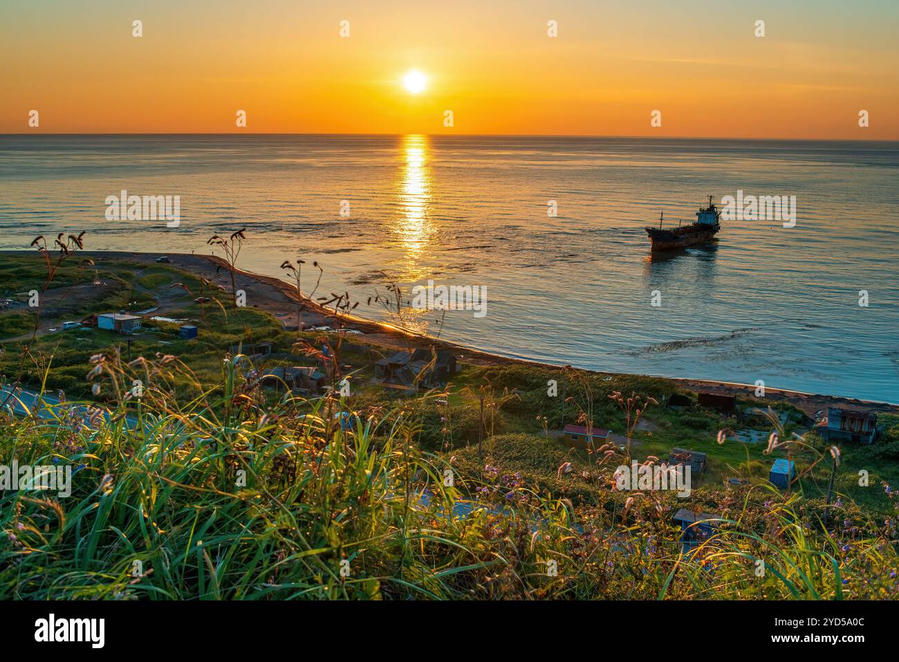 Wunderschöner Sonnenuntergang über dem Meer mit Öltankschiff im Vordergrund. Nevelsk, Sachalin, Russland Stockfoto