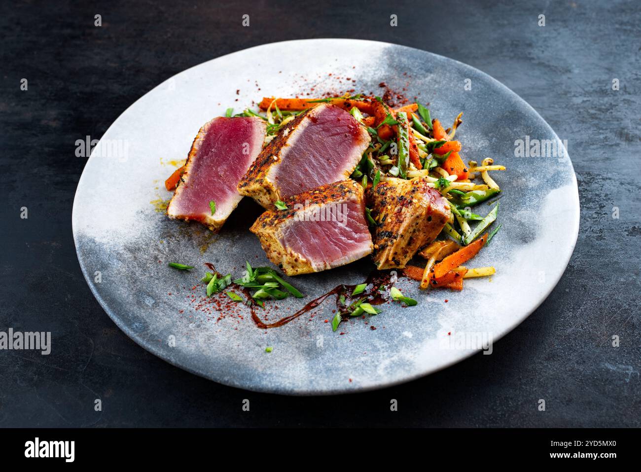 Traditionelles japanisches Gourmet-Thunfischsteak Tataki mit Gemüsescheiben und Sojasprossen mit süßer Sauersauce serviert als Nahaufnahme im nordischen Design Stockfoto