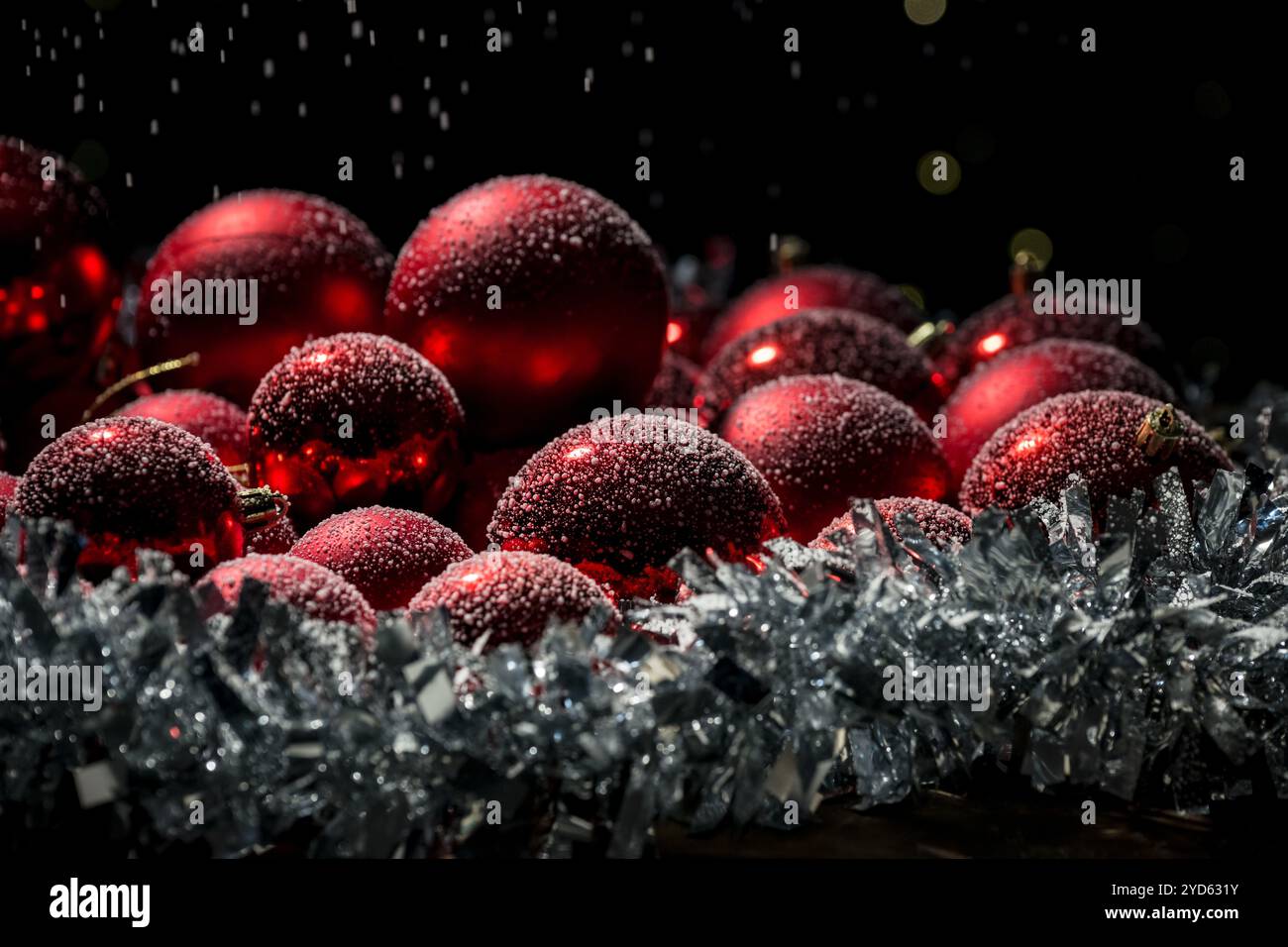 Weihnachtsbaumdekor und Neujahr: Rote Kugeln mit Schneeflocken bedeckt, wunderschön animierter Schneefall, Nahaufnahme. Stockfoto