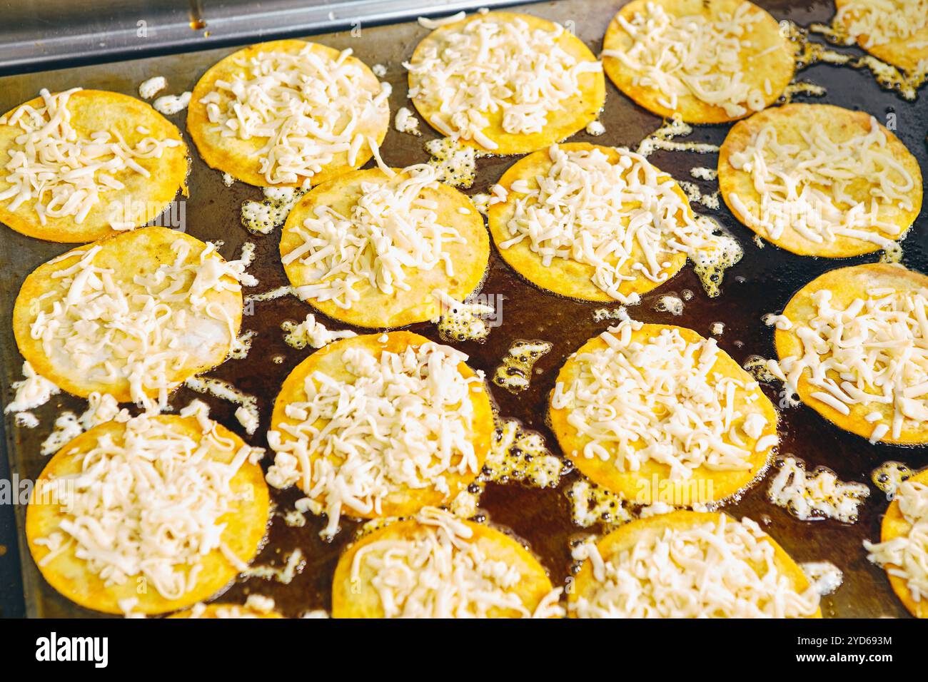 Braten von Tacos Tortillas mit Käse auf Grillplatte in der professionellen Küche im Restaurant. Mexikanische Küche, lateinamerikanisches Fast Food Stockfoto