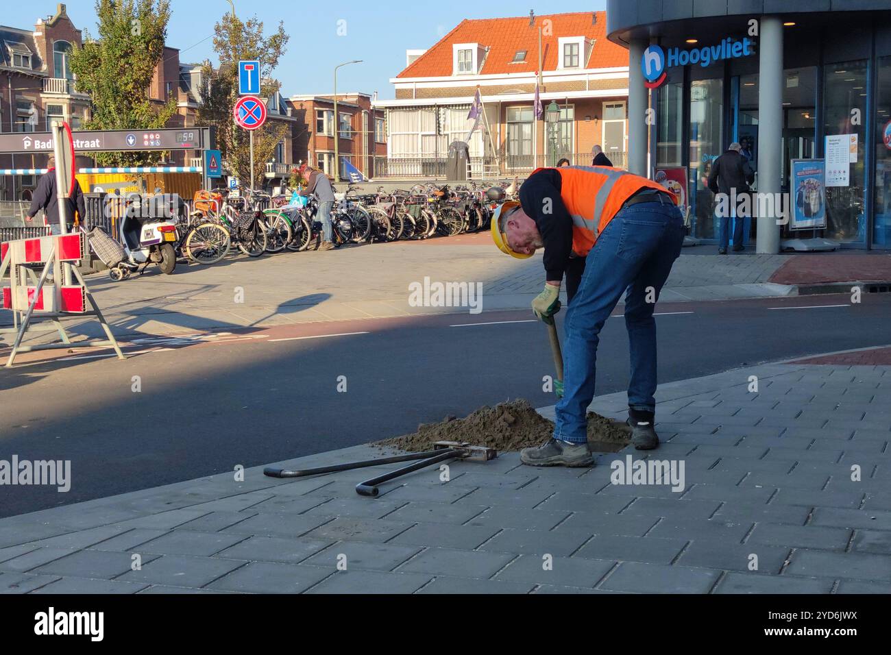 Der Arbeiter gräbt ein Loch, um später ein Verkehrsschild hineinzubringen Stockfoto