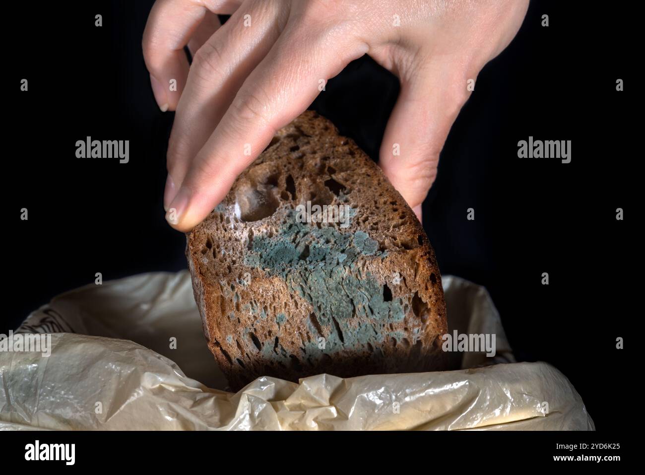 Menschliche Hand hält alte Roggenbrote, Frieden verdorbenes Essen Stockfoto