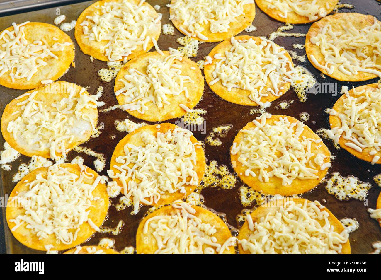 Braten von Tacos Tortillas mit Käse auf Grillplatte in der professionellen Küche im Restaurant. Mexikanische Küche, lateinamerikanisches Fast Food Stockfoto