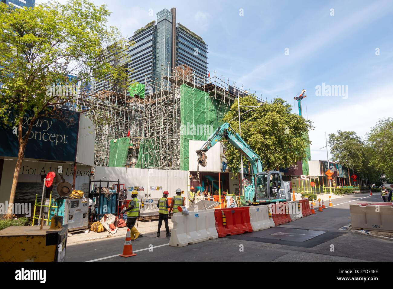 Straßenbauarbeiten, Kobelco-Bagger, Arbeiter-Team, Bauarbeiten im Downtown Financial District Singapur Stockfoto