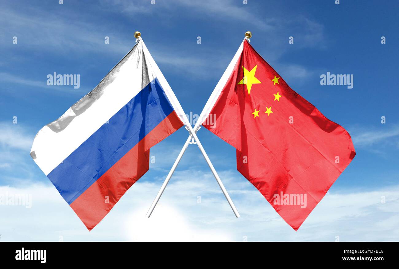 Russische und chinesische Flagge am bewölkten Himmel. Winken Sie in den Himmel Stockfoto