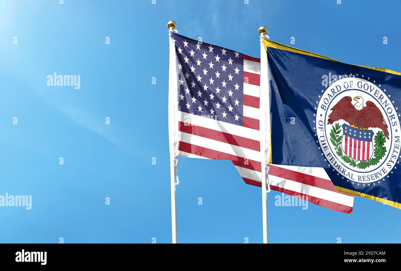 Amerikanische Flagge und US Federal Reserve mit blauem Himmel. Im Himmel winken Stockfoto