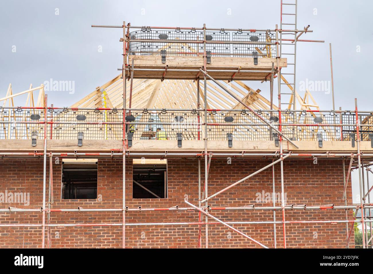 Blick auf ein neu erbautes Haus auf einer Baustelle mit Gerüsten. Dachkonstruktion. Stockfoto