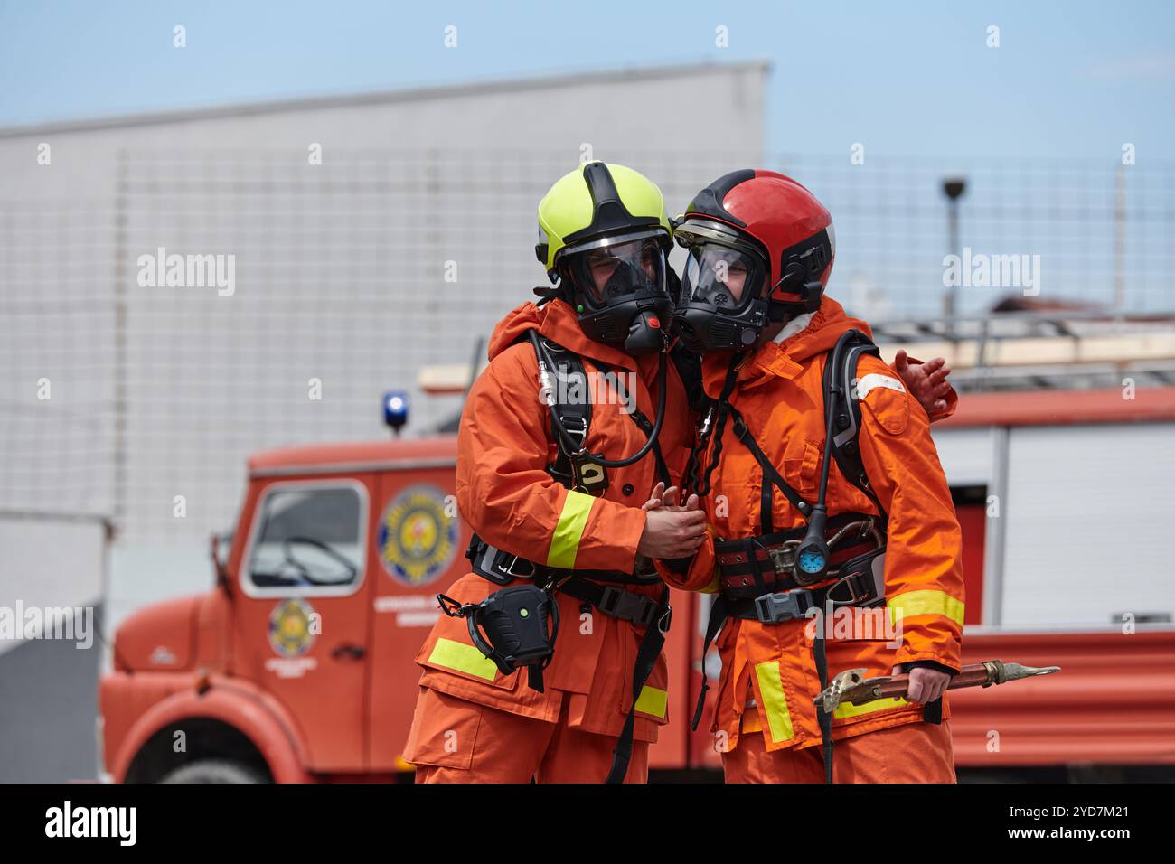 Ein vereintes Team von Feuerwehrleuten, die in ihren Uniformen verziert sind, feiert eine herzliche Feier, die von triumphalen Grußworten und c Stockfoto