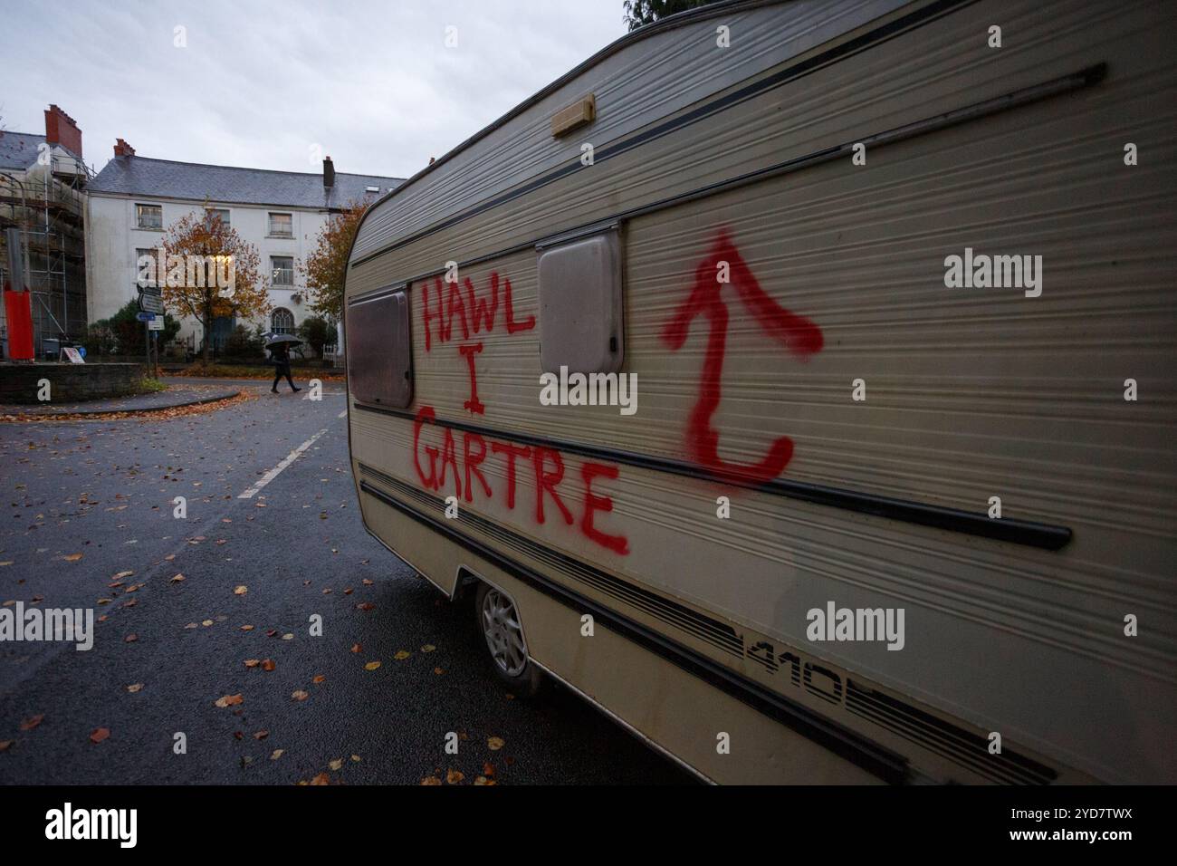 Carmarthen, Großbritannien. 25. Oktober 2024. Eine Karawane wird vor den walisischen Regierungsbüros in Carmarthen verlassen, die mit Graffiti befüllt ist, die die Menschen zum Recht auf Wohnung auffordern, nachdem die walisische Regierung vermeintlich nicht aktiv war. Gruffydd Thomas/Alamy Stockfoto