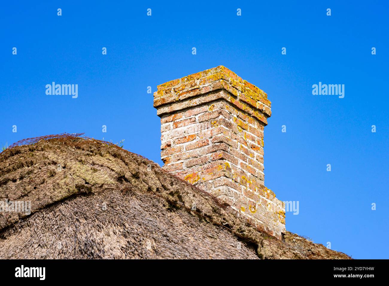 Alter gemauerter Kamin auf dem Dach eines Hauses vor dem blauen Himmel Stockfoto