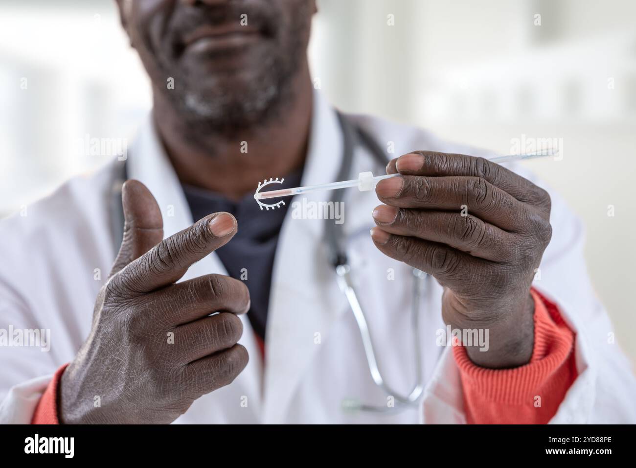 Gynäkologe zeigt auf eine IUD. Stockfoto