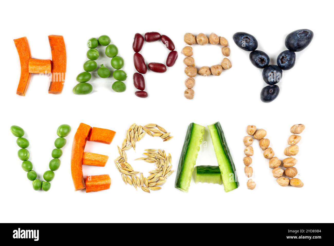 FRÖHLICHER VEGANER Text aus Buchstaben in Getreide und Gemüse auf weißem Hintergrund als Symbol für vegane oder vegetarische Ernährung ohne tierische Produkte. Stockfoto