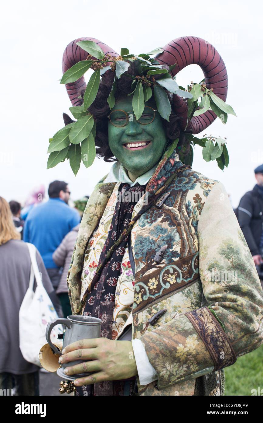 Lächelnder grüner Mann in Vintage-gemustertem Kostüm mit gehörntem Kopfschmuck und Grün beim Jack in the Green Festival, das Frühling und Folklore feiert. Stockfoto