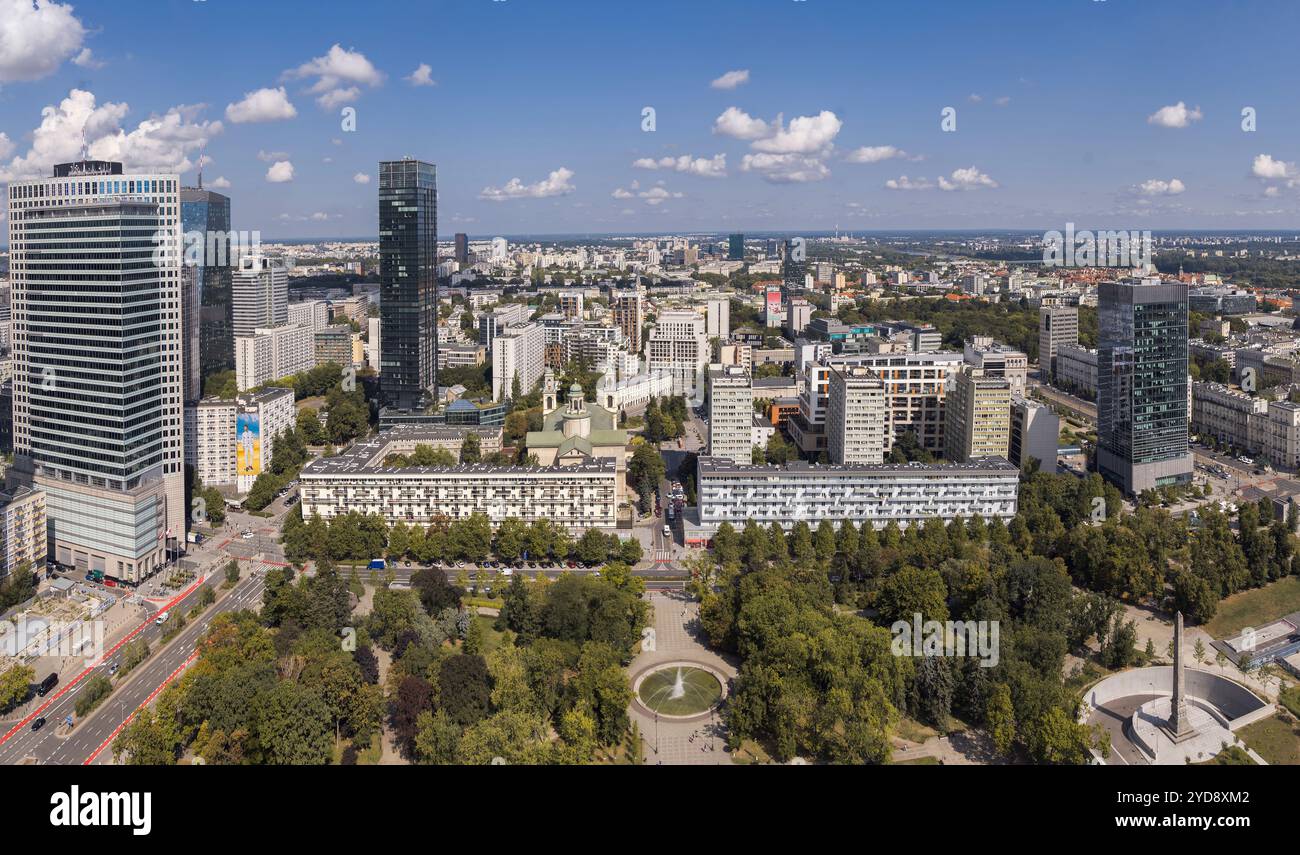 Die pulsierende Skyline von Warschau besticht durch elegante Gebäude inmitten üppiger Parks, die im Sonnenlicht getaucht sind Stockfoto